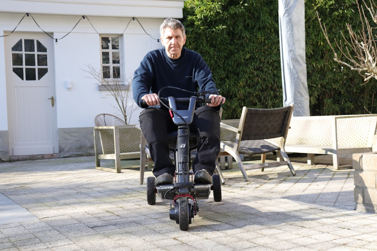 A man riding an electric three-wheeled scooter outdoors.